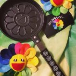 Flowers pancake maker by Takashi Murakami with black handle, inspired by colorful flower designs.