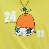Bright yellow T-shirt featuring a cartoon girl with large eyes and orange hair, inspired by Yoshitom.