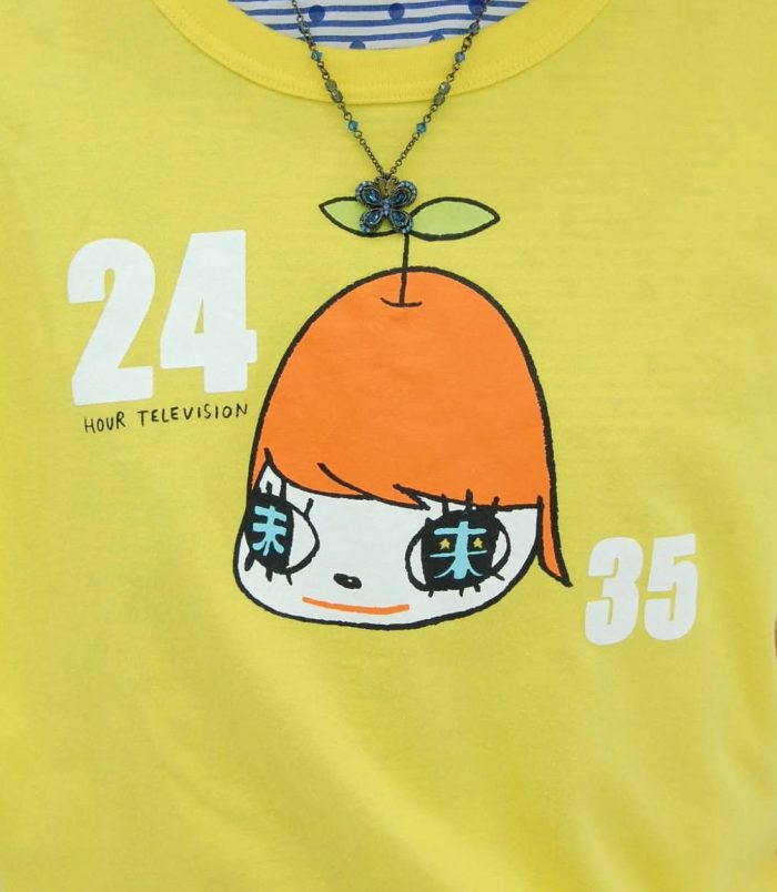 Bright yellow T-shirt featuring a cartoon girl with large eyes and orange hair, inspired by Yoshitom.
