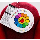 Bright red flower cushion with Murakami-inspired smiley face design.