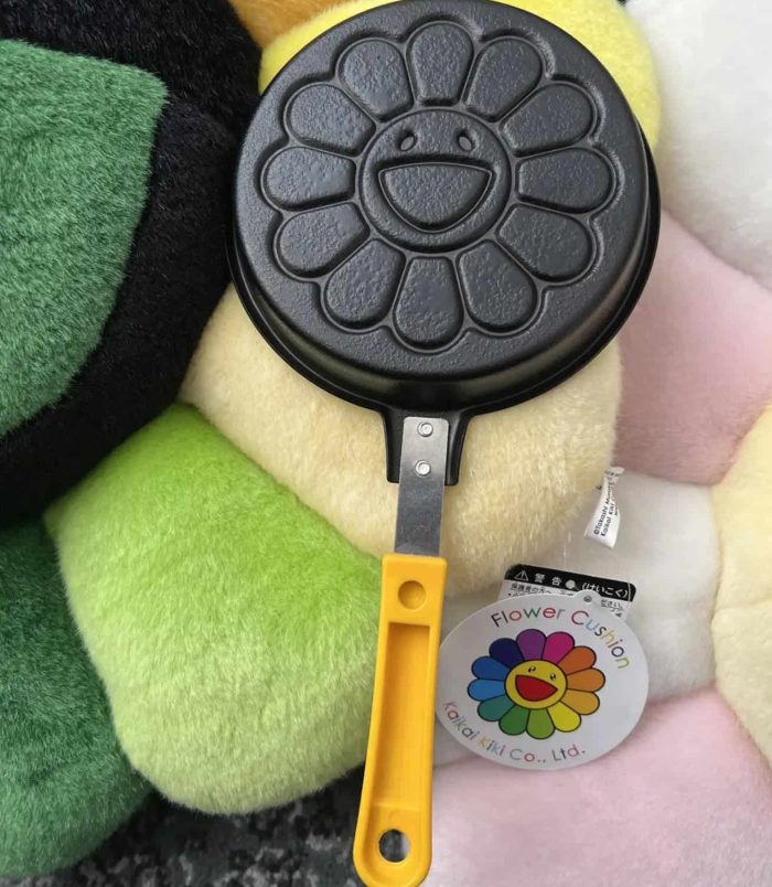 Cute flower-shaped pancake maker with yellow handle, perfect for creating cheerful breakfast treats.