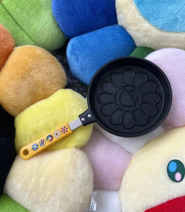 Bright yellow pancake mold with flower design and colorful handle, perfect for creative breakfast pr.