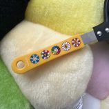 Pancake maker with a colorful flower design and yellow handle, perfect for creating fun, flower-shap.
