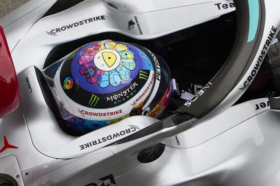 Helmet with colorful floral design and Monster Energy logo on a racing car.