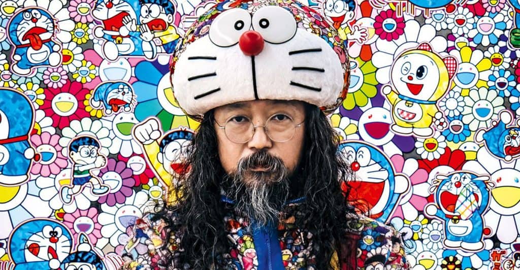 Doraemon plush hat worn by a man with long hair and glasses, vibrant cartoon background featuring Do.