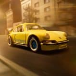 Yellow Porsche toy car, detailed and vibrant, racing through city streets at night.