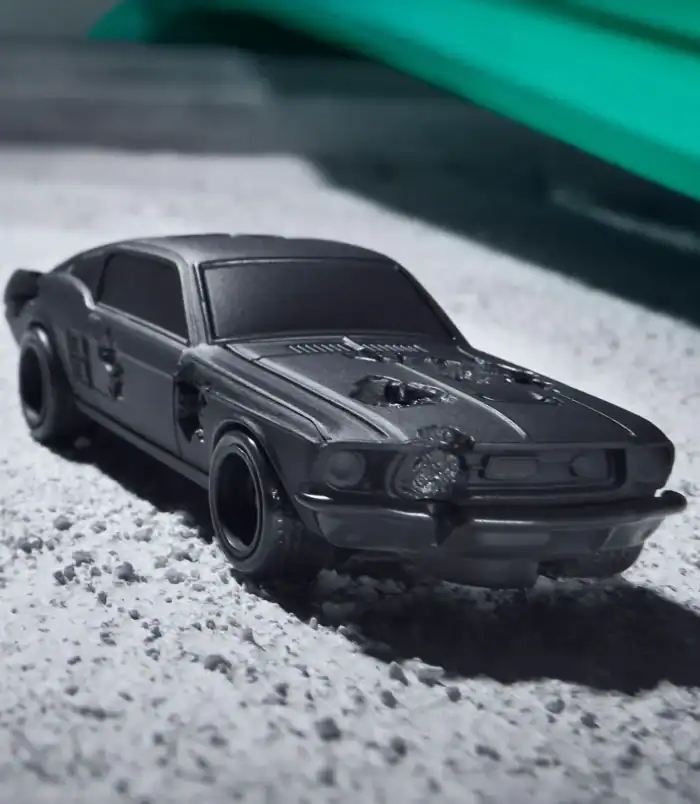 Black vintage toy car on a textured surface, detailed miniature model. Vintage black toy car with detailed features, perfect for collectors and enthusiasts.