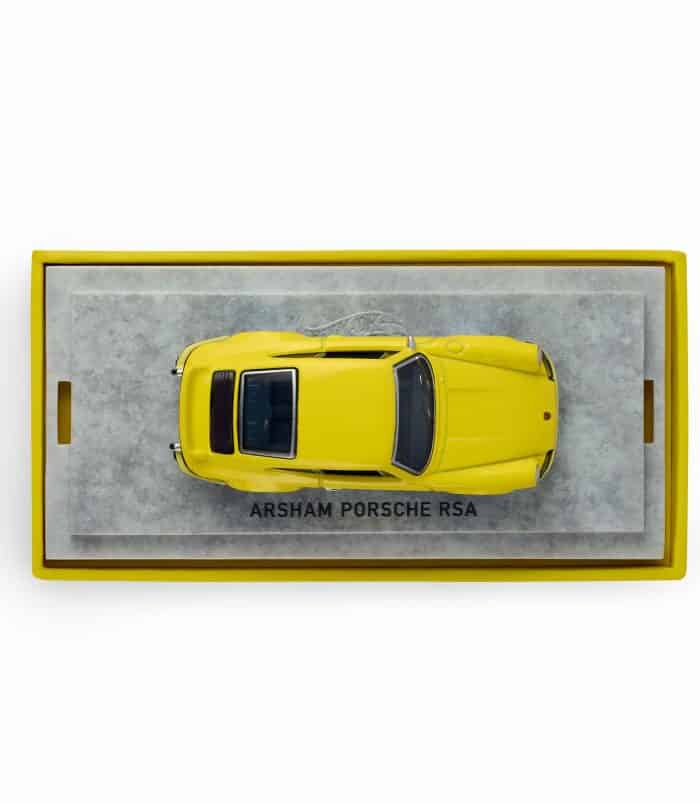 Porsche RS4 model in yellow with display box Yellow Porsche RS4 model car on display in a box.